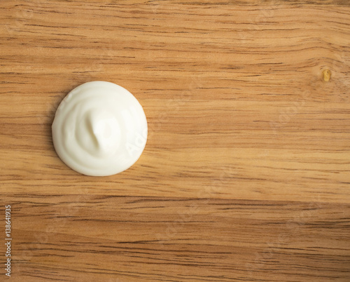 Sour Cream Swirl or White Yogurt on a Wooden Background