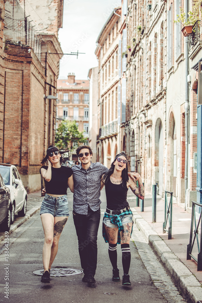 Trois jeunes personnes marchent dans la rue, paysage urbain