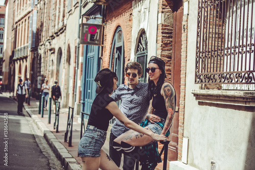 Trois jeunes personnes discutent dans la rue, paysage urbain © Warpedgalerie