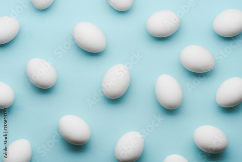 Fototapeta Naklejka Na Ścianę i Meble -  White eggs chaotic pattern on mint color background