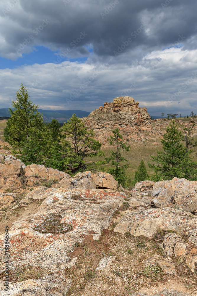 Fototapeta premium Mountain landscape with textured rocks, coniferous trees and heart form in the foreground. View from above