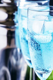 Blue cocktail with liquor, soda and ice in glasses, selective focus