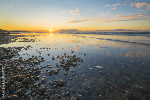 Baltic sea at beautiful sunrise,stony beach after storm