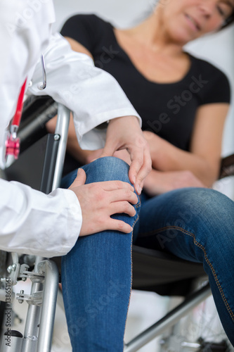 male orthopedic doctor examining womans knee in clinic