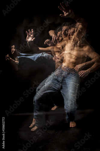 Strobo portrait of shirtless wrestler man . Black background