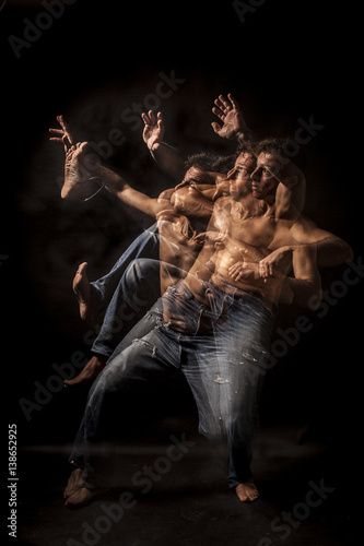 Strobo portrait of shirtless wrestler man . Black background