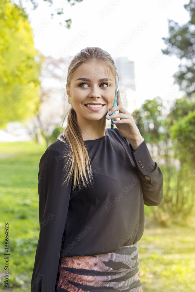 Young beautiful smiling woman talking on cell phone spring time Young beautiful smiling woman talking on cell phone spring time