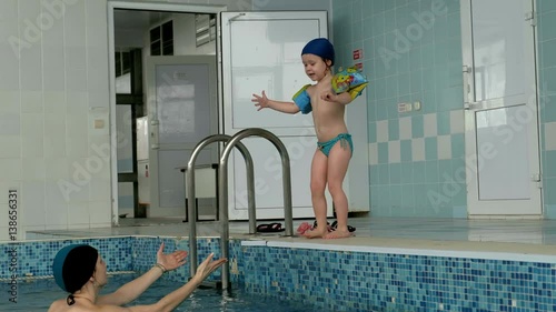 Mother and baby swimming in swimming pool photo