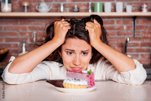 Woman on the diet craving to eat cake. diet concept photo