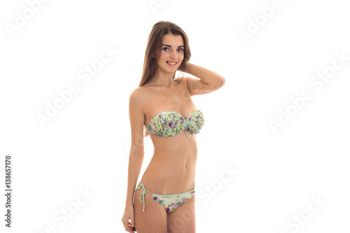 young charming girl in a bathing suit stands sideways and smiling