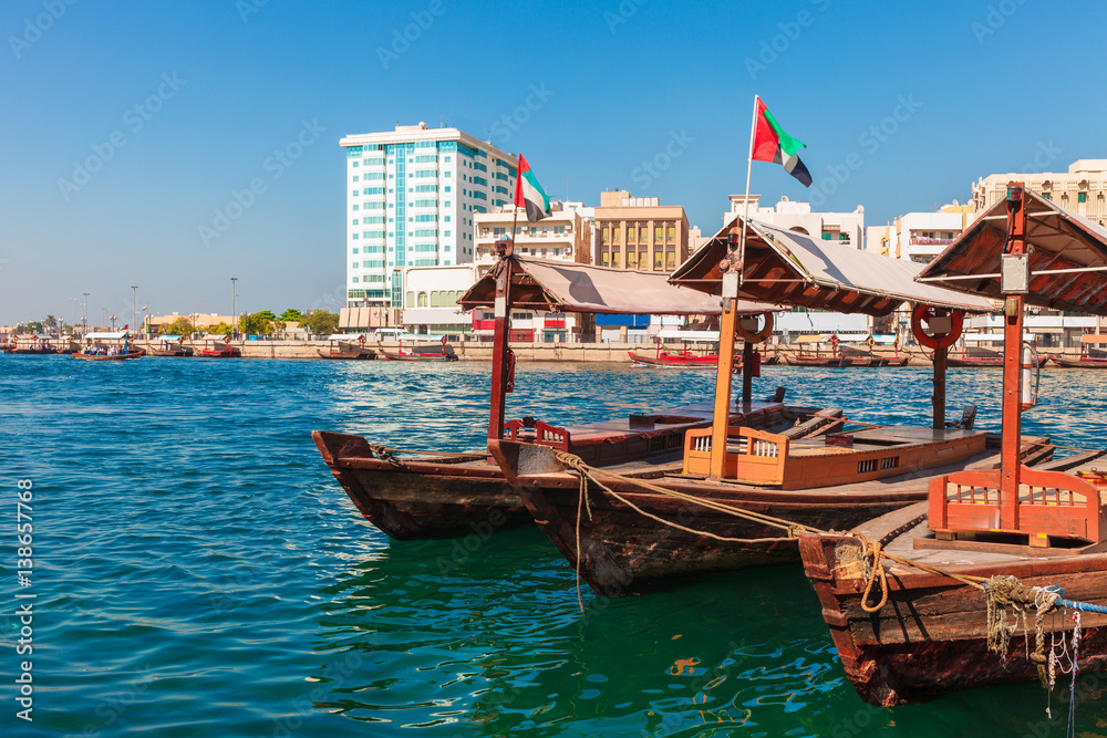 Fototapeta premium Piers of traditional water taxi boats in Dubai, UAE. Panoramic view on Creek gulf and Deira area. Famous tourist destination United Arab Emirates