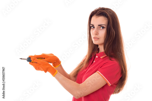 young serious girl in red t-shirt and gloves held out in the hands of instrument