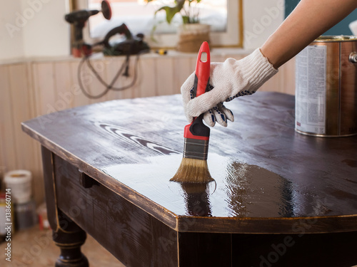 Covering varnish of old wooden table. Restoration of furniture.