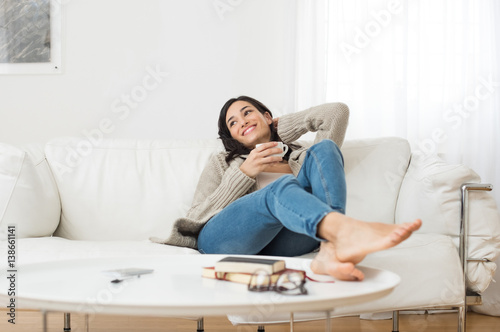 Smiling woman thinking on sofa