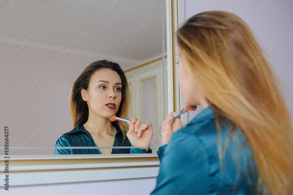 applying dry cosmetic tonal foundation on the face using makeup brush. applying dry cosmetic tonal foundation on the face using makeup brush.