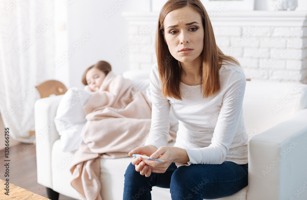 Troubled mother taking care of her sick daughter Troubled mother taking care of her sick daughter