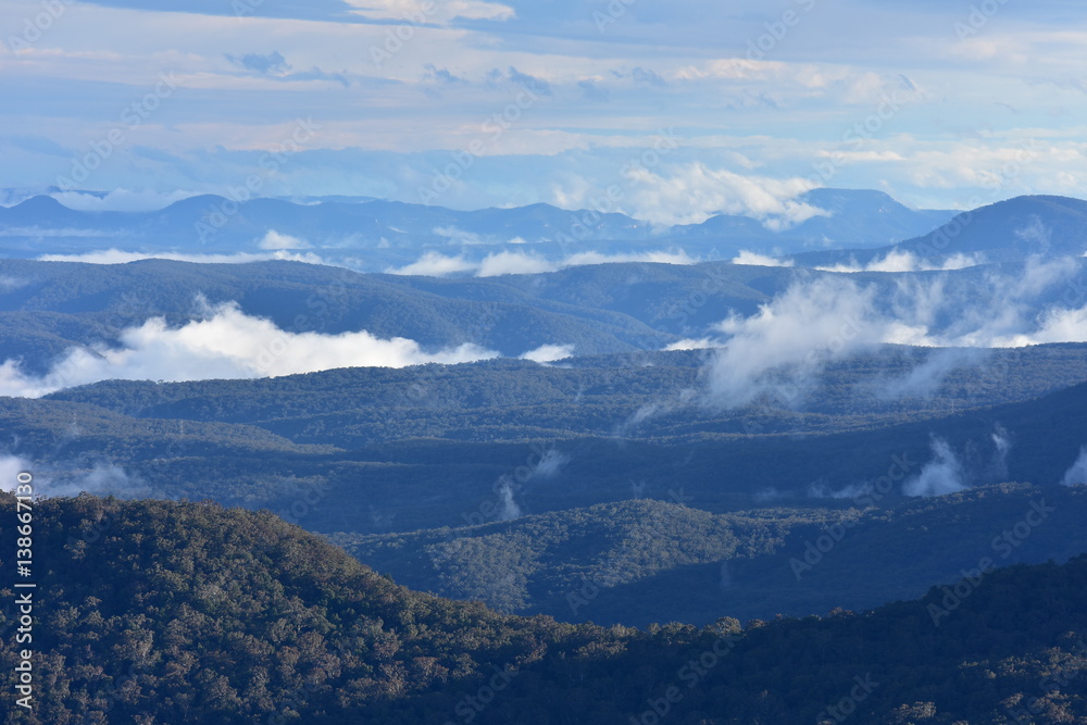 Blue Mountains with low patchy clouds in evening light.