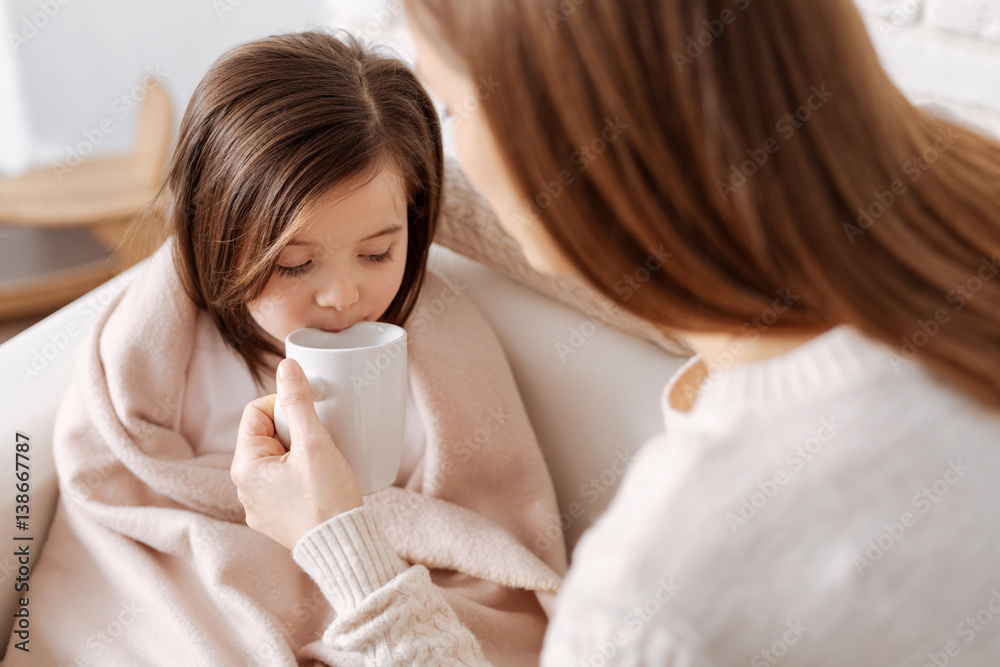 Pleasant loving mother helping little girl to recover Pleasant loving mother helping little girl to recover