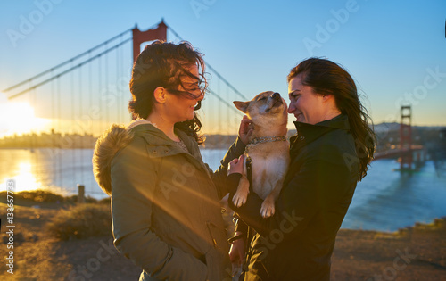 Photography lesbian couple with shiba inu pet dog in front of golden gate bridge at sunrise