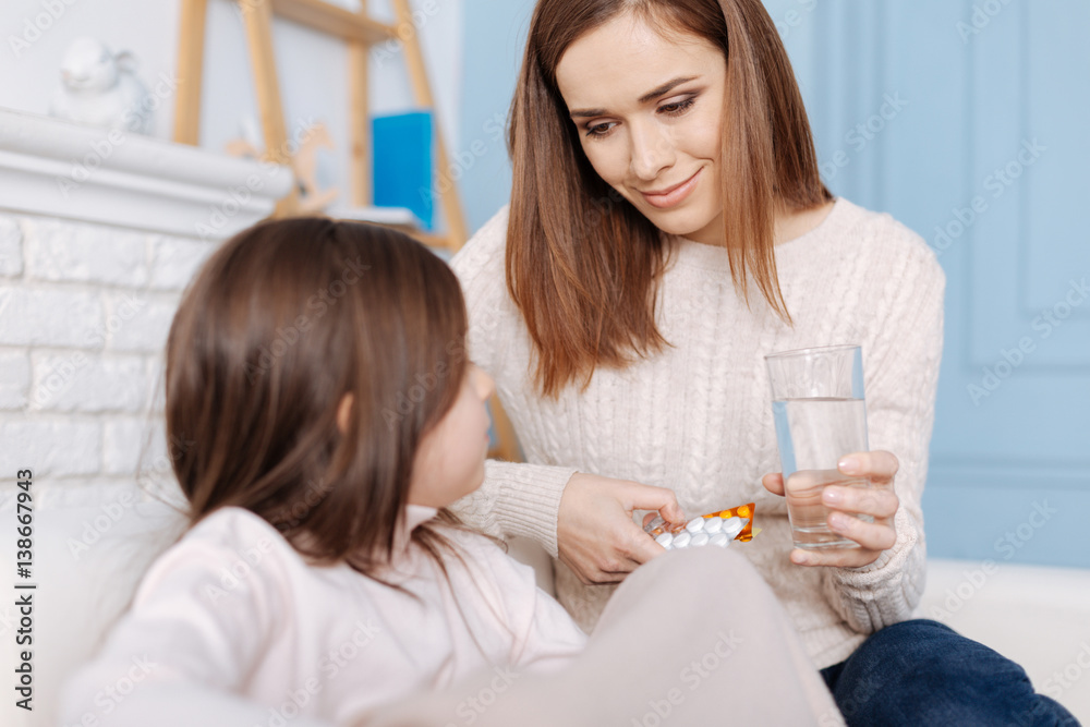 Pleasant smiling mother helping to recover her little daughter Pleasant smiling mother helping to recover her little daughter