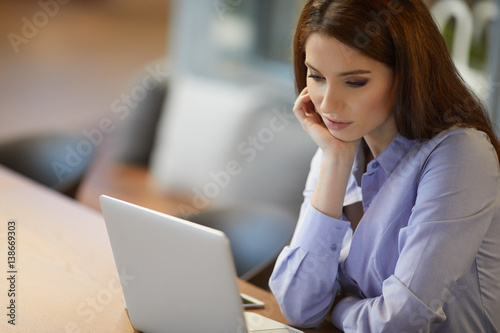 Portrait of successful businesswoman working with laptop in office