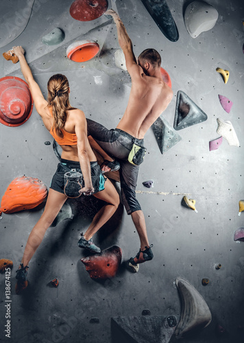 Male and female climbing on a climbing wall.