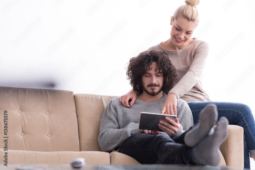 couple relaxing at home with tablet computers couple relaxing at home with tablet computers