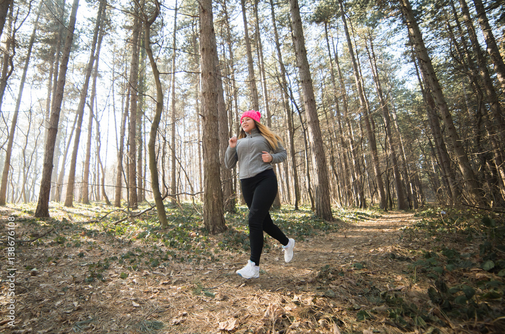Girl wearing sportswear and running in forest at mountain Girl wearing sportswear and running in forest at mountain