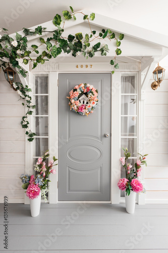 White small wooden house with gray door. spring flower decoration