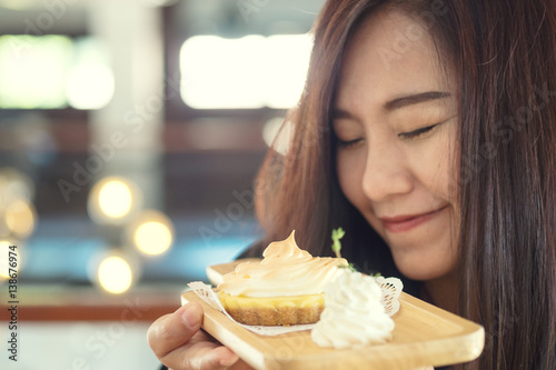 A Beautiful asian woman smelling sweet dessert with feeling happy and good lifestyle in the cafe