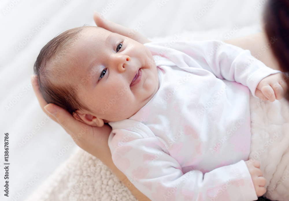 Gently mother hands holding baby . Plump and beautiful newborn stares at her mother.gentle. Gently mother hands holding baby . Plump and beautiful newborn stares at her mother.gentle.