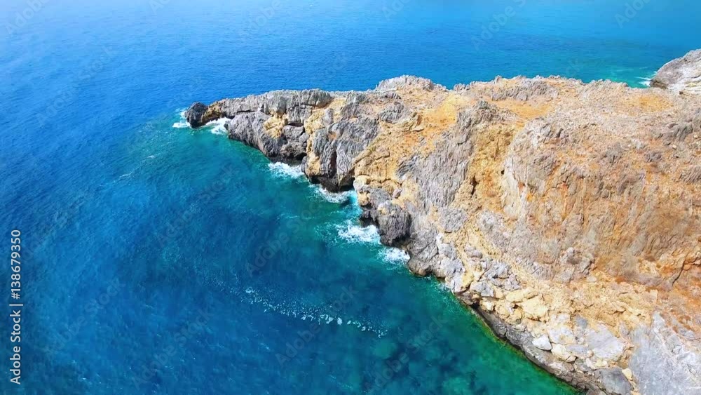 Blue sea, waves breaking in cliffs at shore Blue sea, waves breaking in cliffs at shore