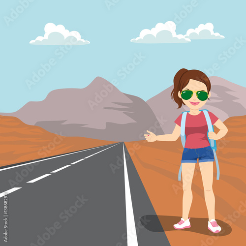 Beautiful young woman with backpack hitchhiking standing on road side