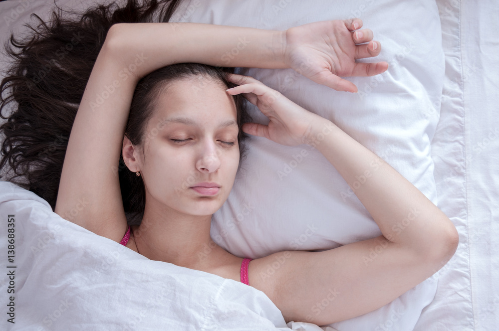 Girl brunette sleeping in her bed on white pillow Girl brunette sleeping in her bed on white pillow