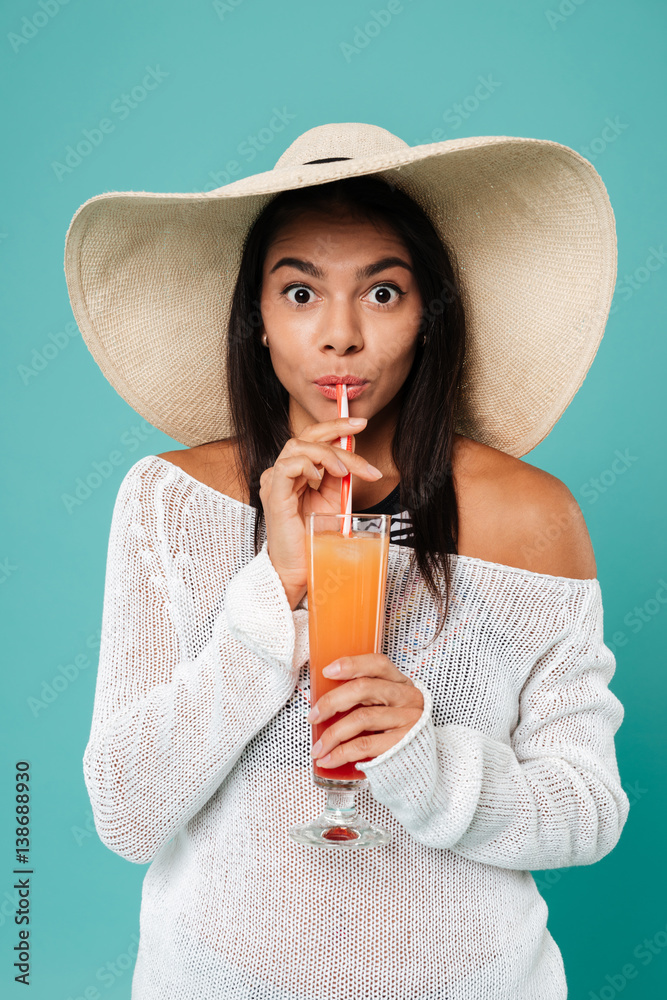 Cheerful young woman wearing hat drinking juice. Cheerful young woman wearing hat drinking juice.