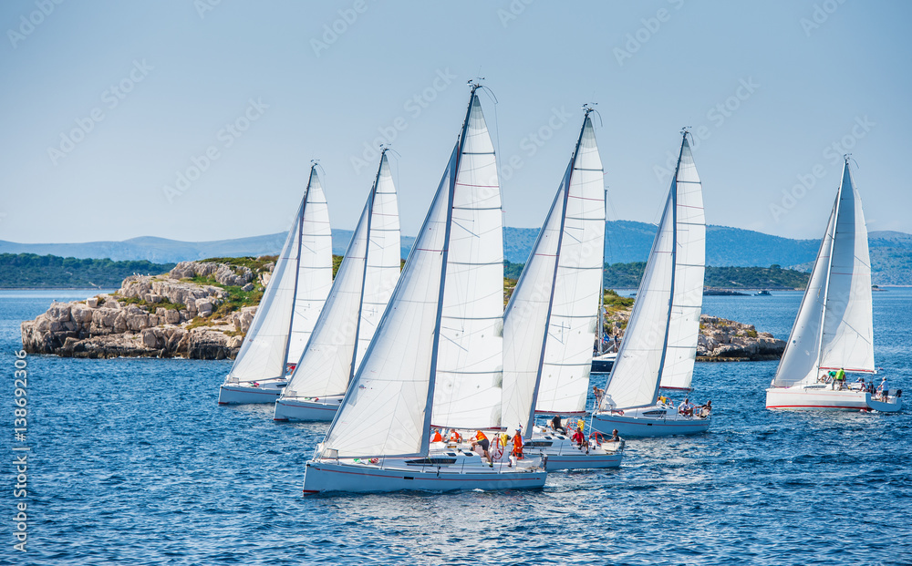 Group of sailing boats during race. Small island in background. Group of sailing boats during race. Small island in background.
