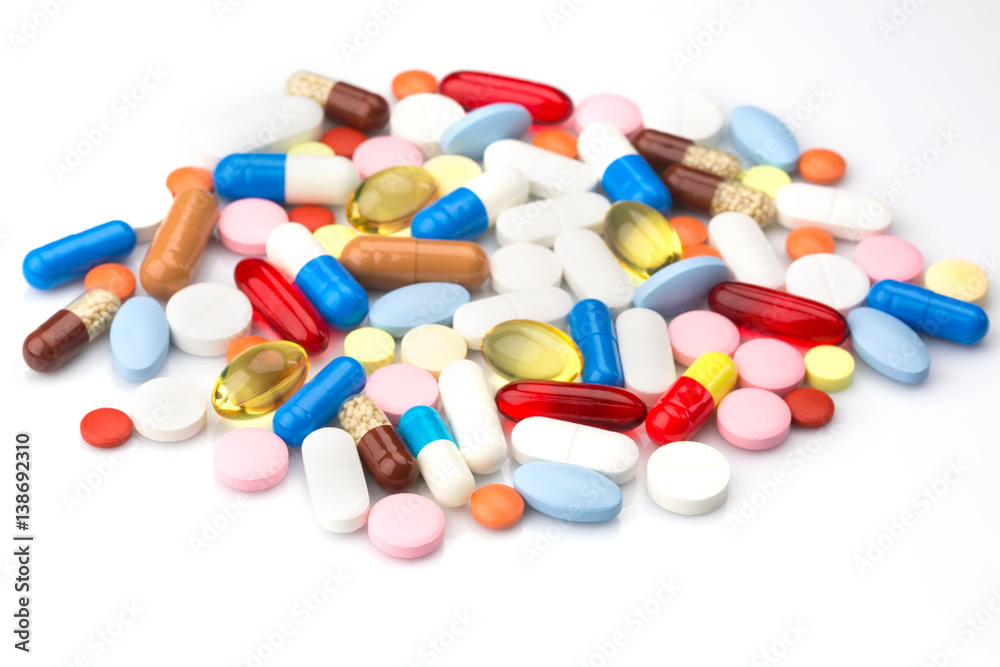 Pharmacy theme. Multicolored Isolated Pills and Capsules on the White Surface. Closeup