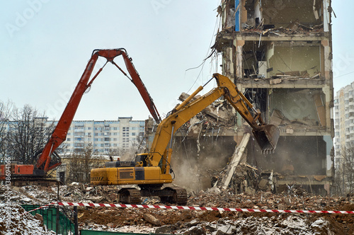 Excavators demoloishing city house