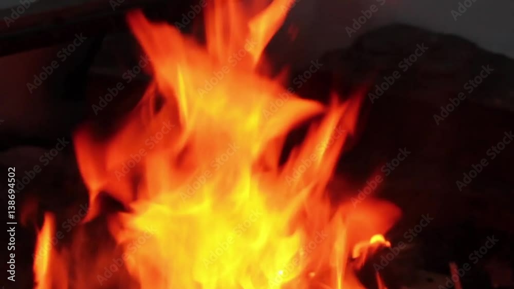 Real flames in the fire with burning logs and snow around Real flames in the fire with burning logs and snow around