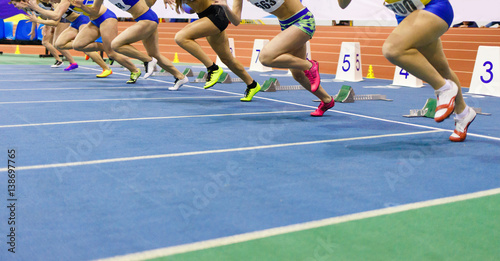 Sportswomen starting run sprint race on track and field competitions photo