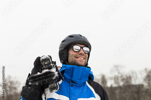 outdoors man portrait holdins skis and smiling © Eva