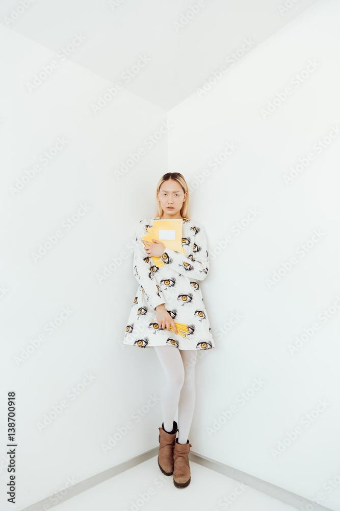 Amazing young asian woman standing over wall with pencils