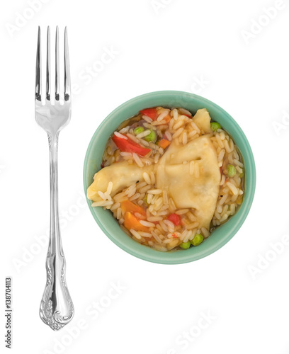 Vegetarian potstickers meal in a green bowl with a fork top the side isolated on a white background.