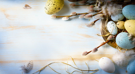Easter background with Easter eggs and spring flowers. Top view with copy space