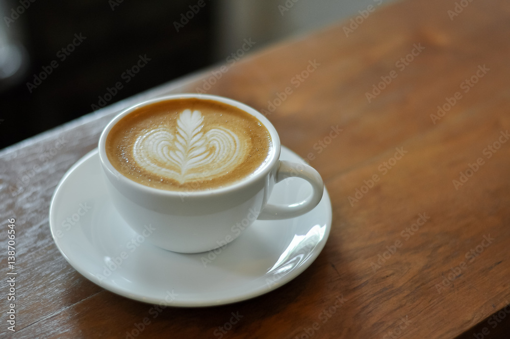 Coffee cup with latte art on the wood table