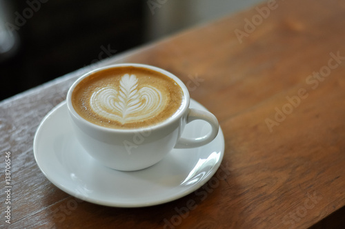 Coffee cup with latte art on the wood table