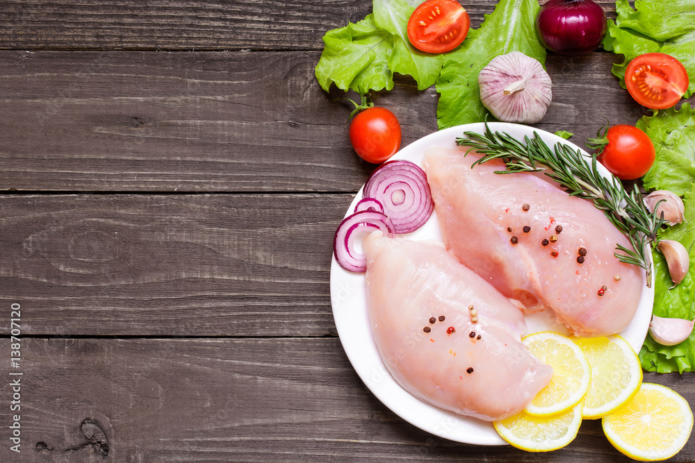 Raw chicken breast fillets on a plate ready for cooking Raw chicken breast fillets on a plate ready for cooking
