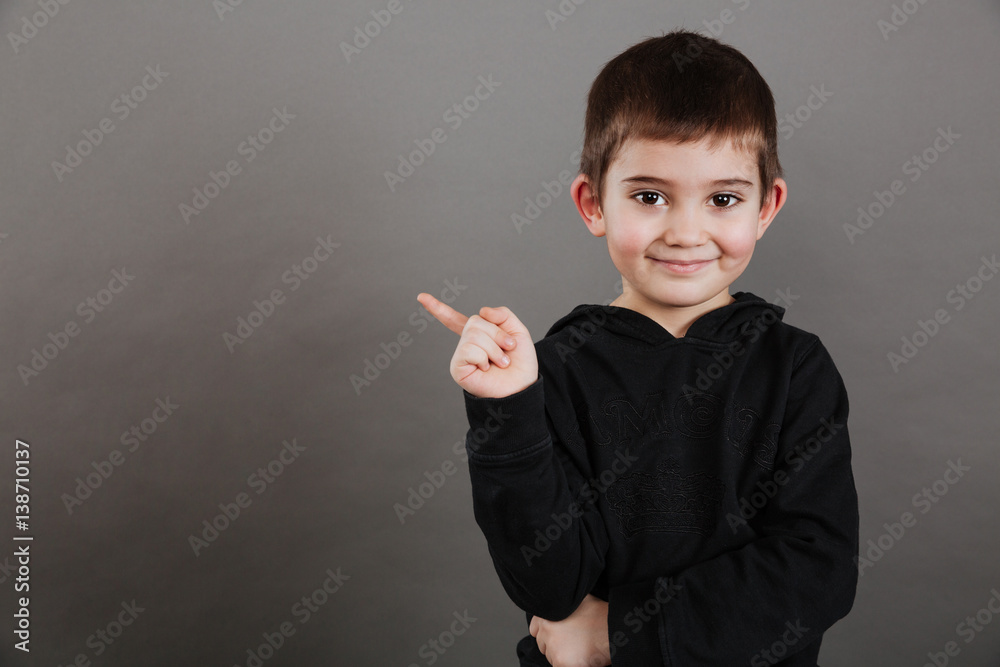 Smiling cute little boy standign and pointing away Smiling cute little boy standign and pointing away