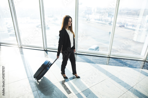 Business woman with laggage bag walking in airport