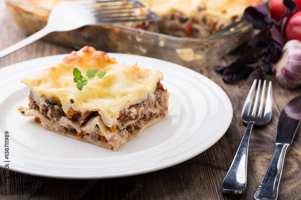 Piece of hot lasagne on white plate